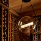 A room with Hubbardton Forge pendant lighting and a lot of wine bottles.