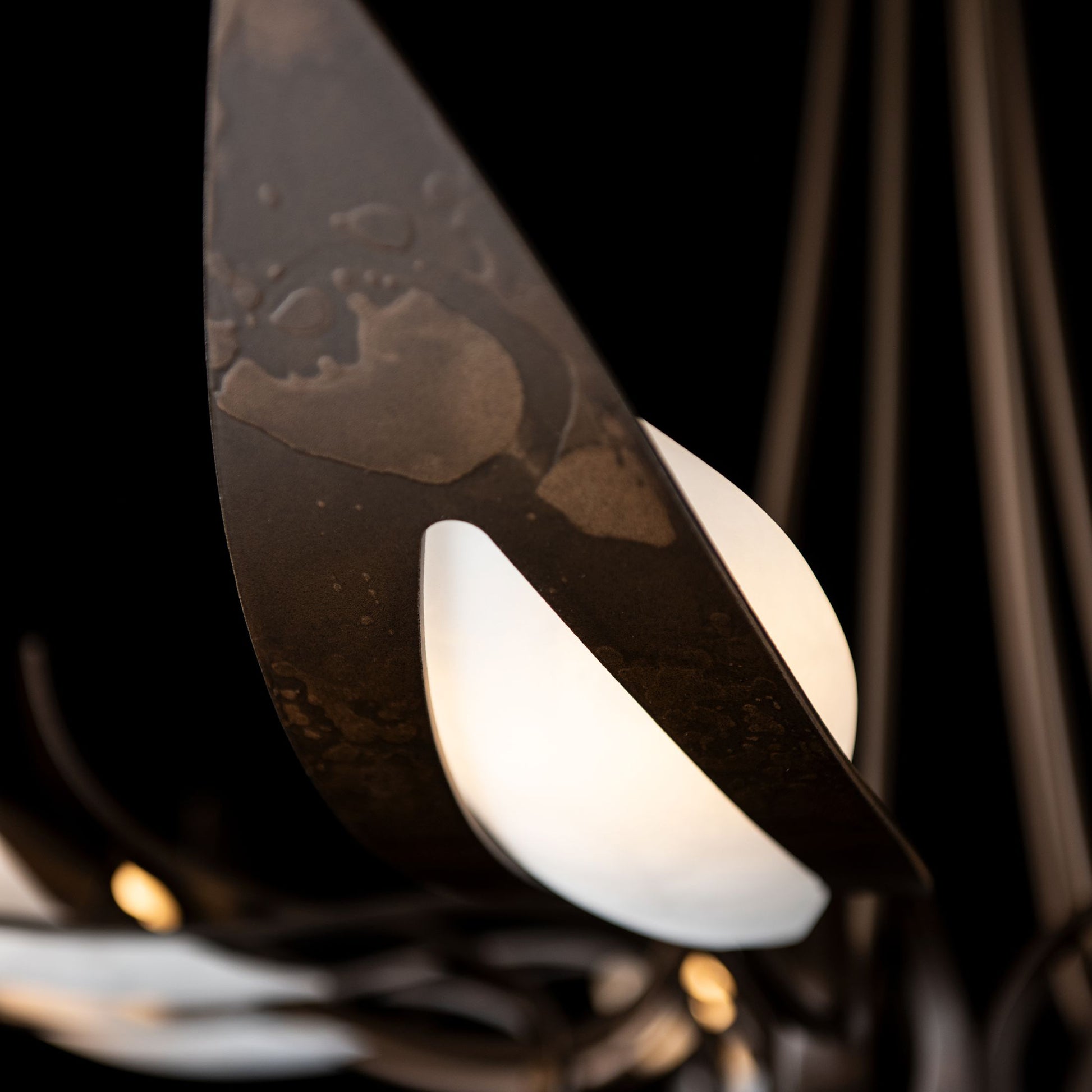 Parasol 7-Light Chandelier by Hubbardton Forge with hand-forged steel leaves and frosted white bulbs, showcasing artisanal American craftsmanship.
