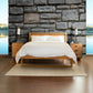A Vermont Furniture Designs Pendant Bed in a room with a stone wall.