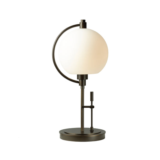 The Pluto Table Lamp by Hubbardton Forge features a white globe on top, reminiscent of Pluto's ethereal glow.