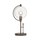 Pluto Table Lamp by Hubbardton Forge featuring a round metal base, circular frame, glass disc accent, and exposed bulb.