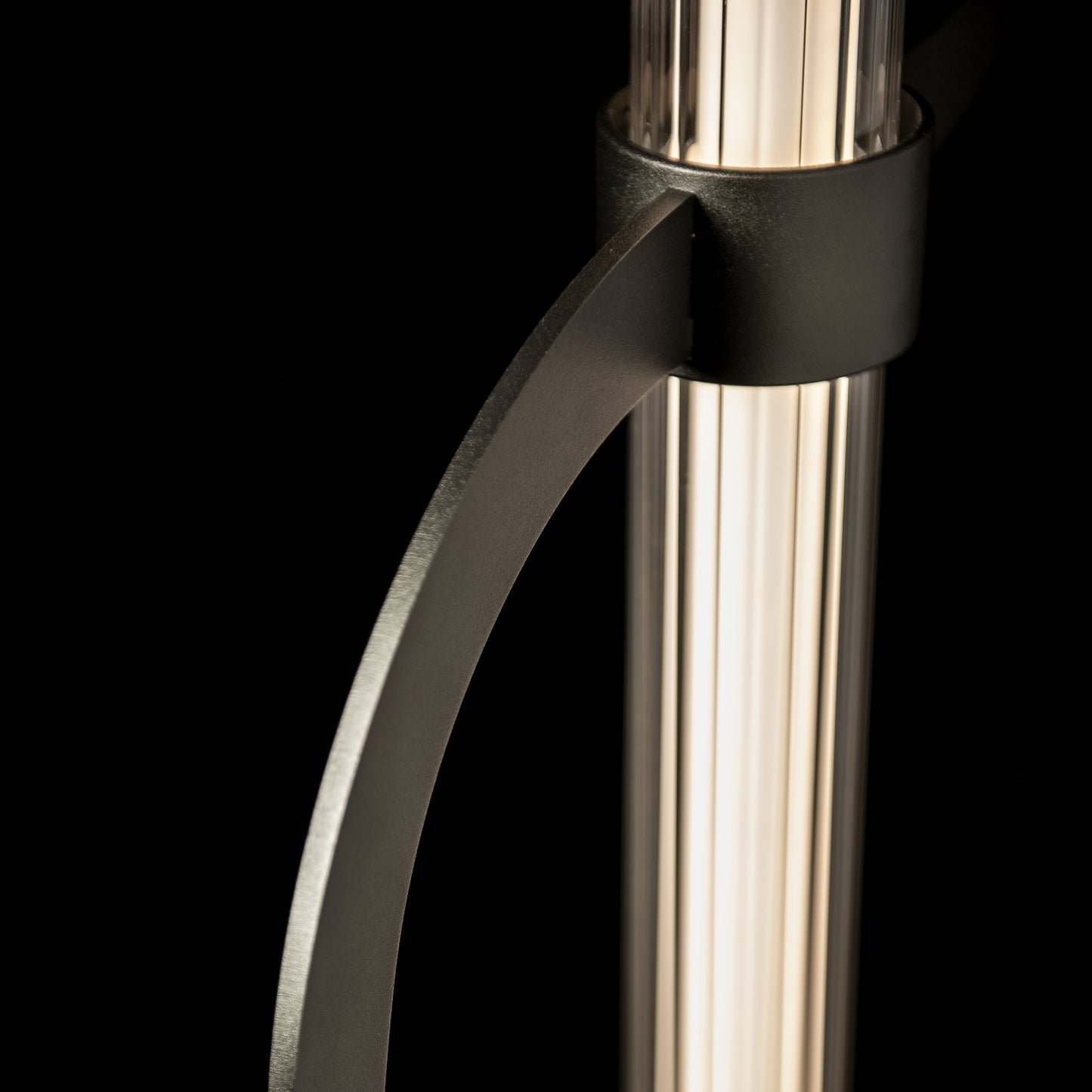 Pulse Floor Lamp by Hubbardton Forge featuring an elegant hand-forged steel arch and clear cylindrical shade.