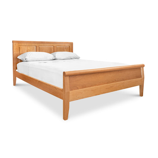 A handcrafted Lyndon Furniture wooden bed with white sheets on a Raised Panel Carriage High Footboard Bed frame.