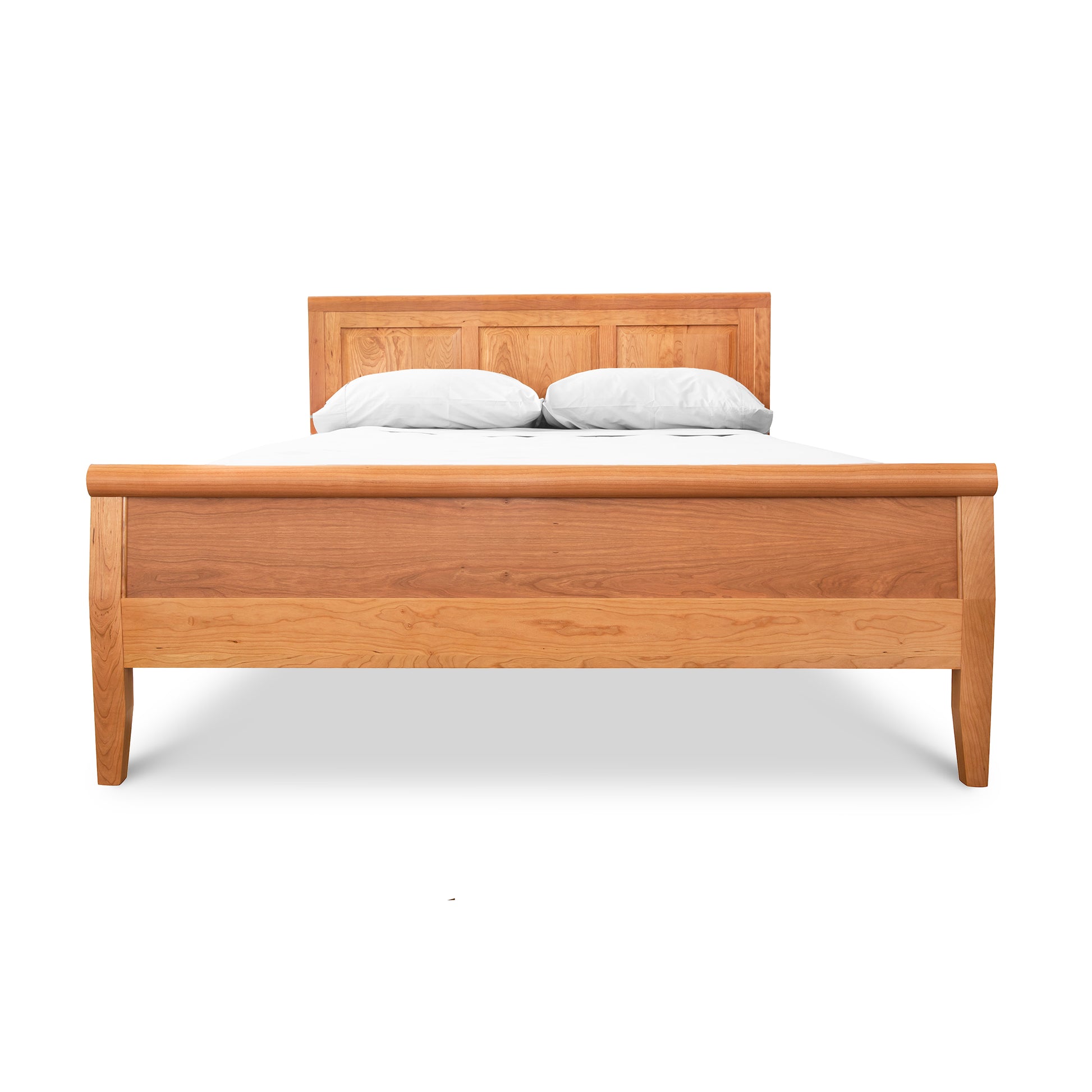 Raised Panel Carriage High Footboard Bed by Lyndon Furniture in solid hardwood with a minimalist headboard, showcasing a white mattress and two pillows.