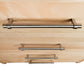 Detail view of stainless steel handles on the Rockingham 5-Drawer Chest by Vermont Woods Studios, showcasing American made wood craftsmanship.