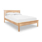 The Rockingham Bed by Vermont Woods Studios showcases a solid wood frame and headboard with crisp white bedding and pillows.
