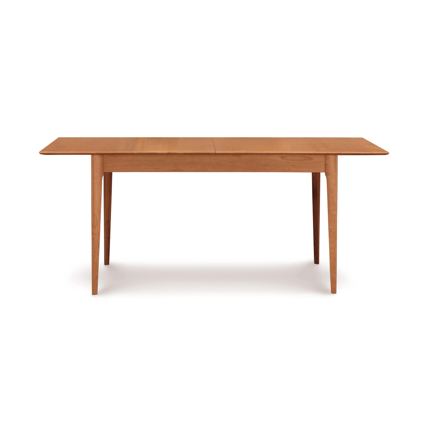 The Sarah Shaker Tapered Leg Extension Table by Copeland Furniture is a rectangular wooden table with a light brown finish, featuring four tapered legs and a smooth, flat surface. Its design is simple and minimalist, characterized by clean lines and no additional adornments, making it perfect for complementing your modern bedroom decor or matching sustainably harvested woods. Measuring 42"x66", it's currently available on clearance.