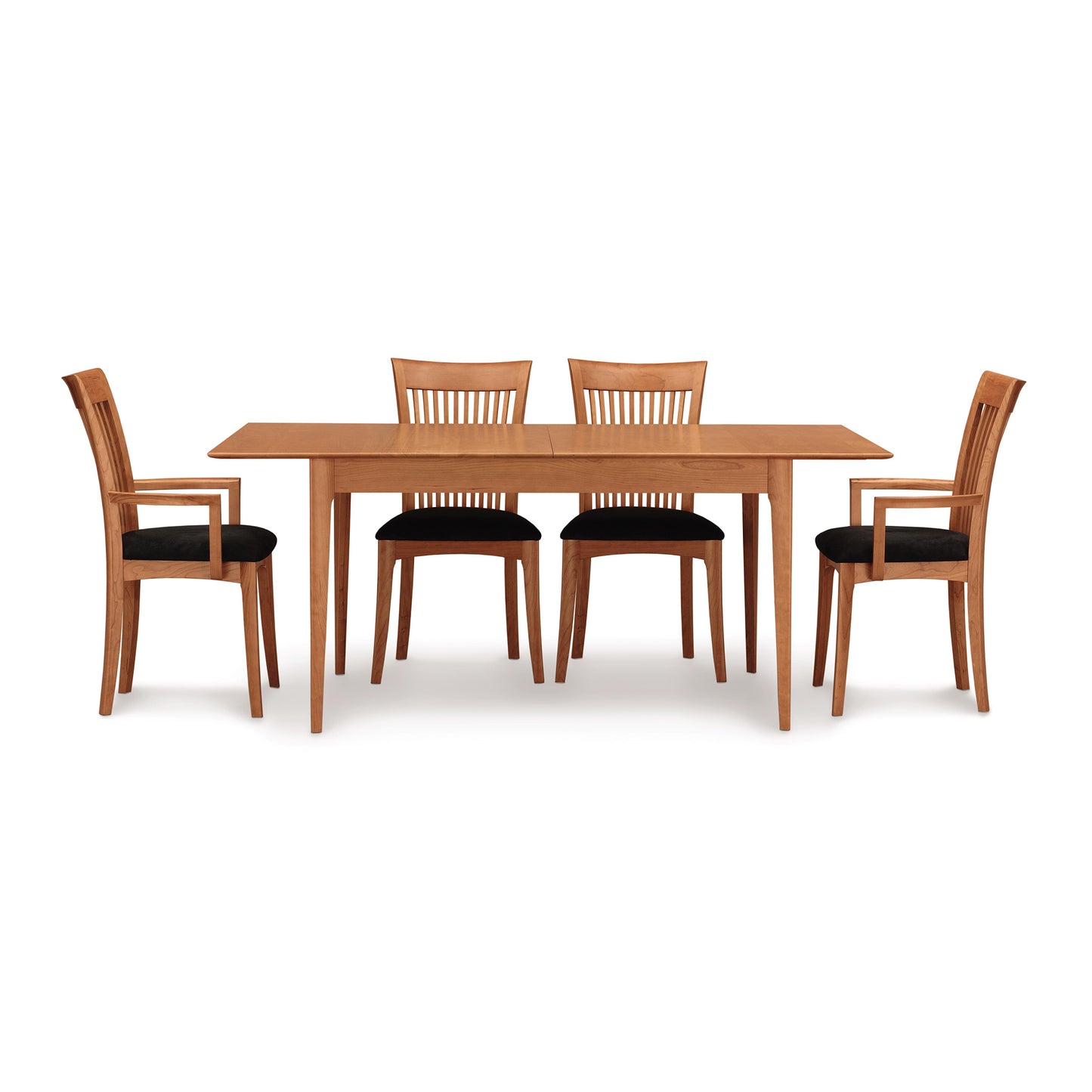 The Sarah Shaker Tapered Leg Extension Table by Copeland Furniture, crafted from sustainably harvested woods, comes with four matching chairs. Each chair features a slatted backrest and black seat cushions. The symmetrical arrangement includes two chairs on each side of the wooden dining table, all set against a white background.