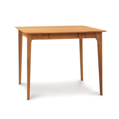 A Sarah Secretary Desk by Copeland Furniture with tapered legs and a single drawer, isolated on a white background.