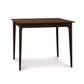 A Sarah Secretary Desk by Copeland Furniture, with a wooden top and legs, showcasing a natural wood color.