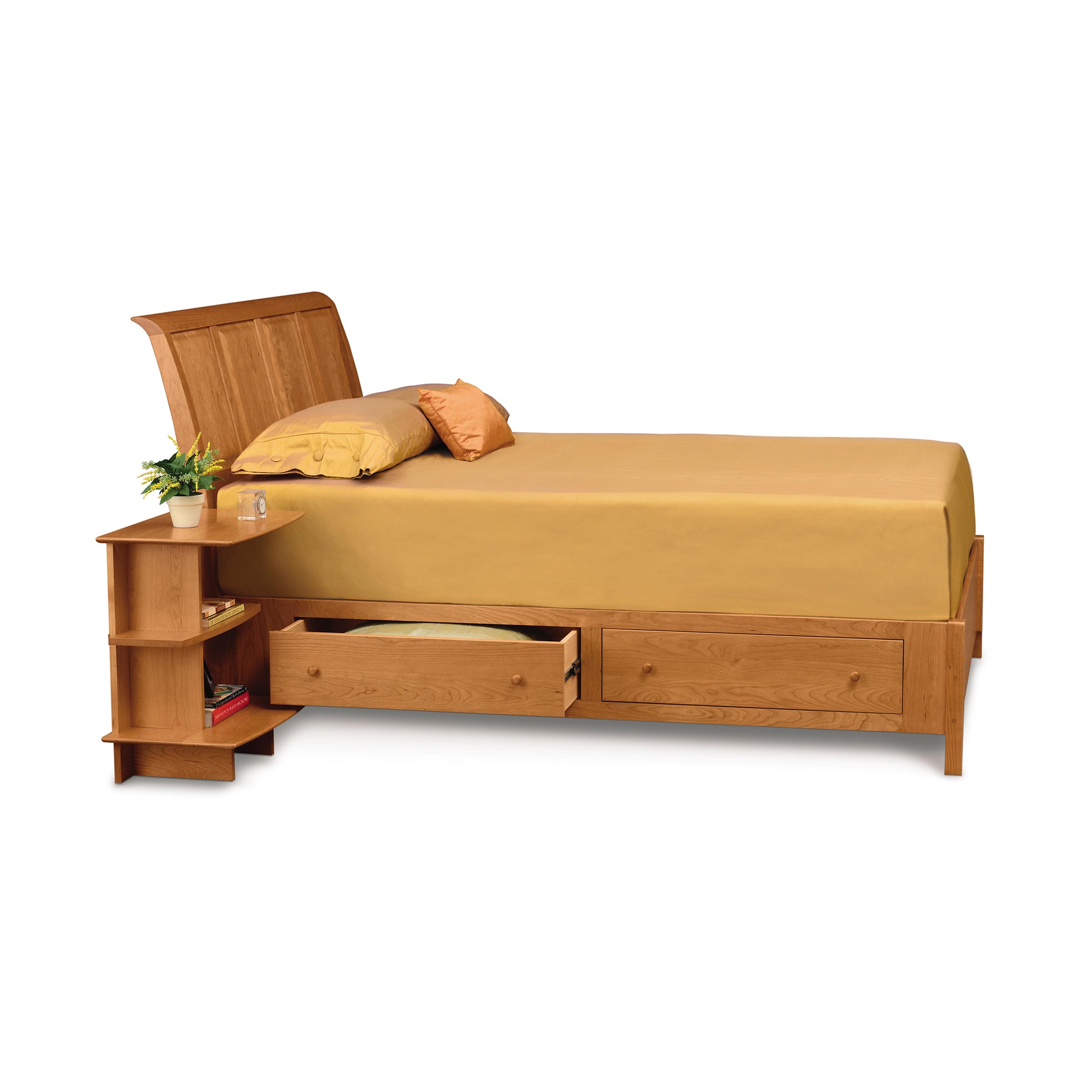 A single Sarah Sleigh Storage Bed by Copeland Furniture with storage drawers and shelves, complete with gold-colored bedding and a small plant on the bedside shelf.