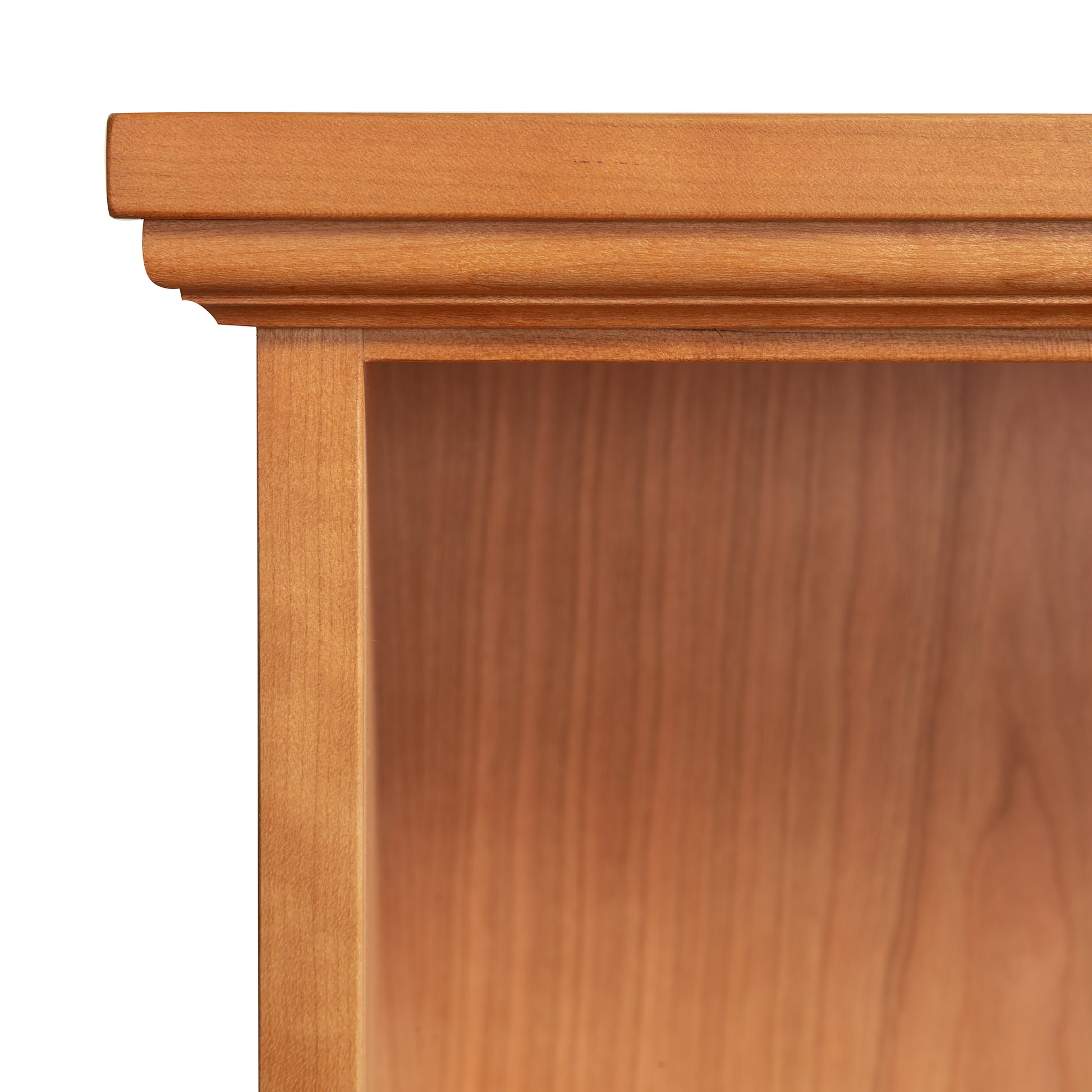 Detailed view of the top left corner of a Lyndon Furniture Shaker Bookcase, showcasing its natural wood finish and signature decorative edge.