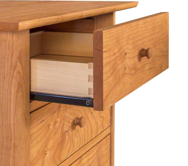 A drawer with a Shaker Knob made by Vermont Furniture Design is open on a Vermont Furniture Designs wooden nightstand.