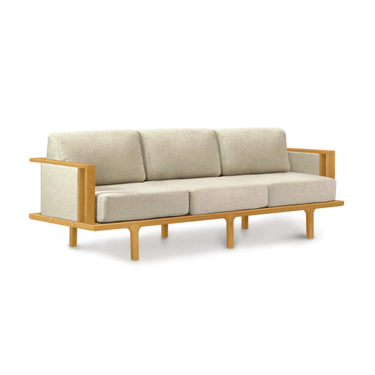A contemporary Sierra Cherry Upholstered Sofa with Upholstered Panels, from Copeland Furniture, with wooden frame and custom upholstery colors, isolated on a white background.