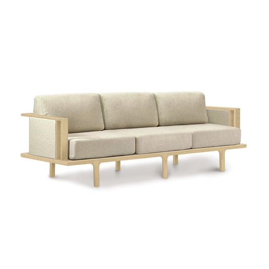 A Sierra Oak Upholstered Sofa with Upholstered Panels by Copeland Furniture with wooden legs on a white background.