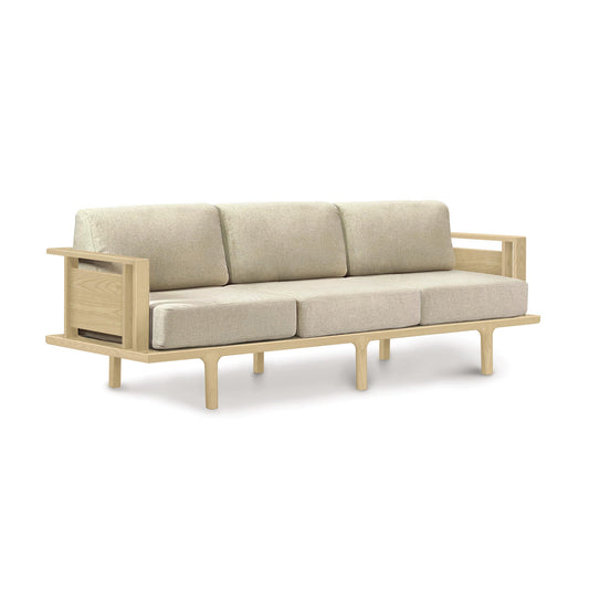 A contemporary beige Copeland Furniture Sierra Oak Upholstered Sofa with a wooden frame and light-colored cushions on a white background.