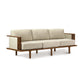 Copeland Furniture's Sierra Walnut Upholstered Sofa with Upholstered Panels, featuring beige cushions and a contemporary design, stands out against a white background.