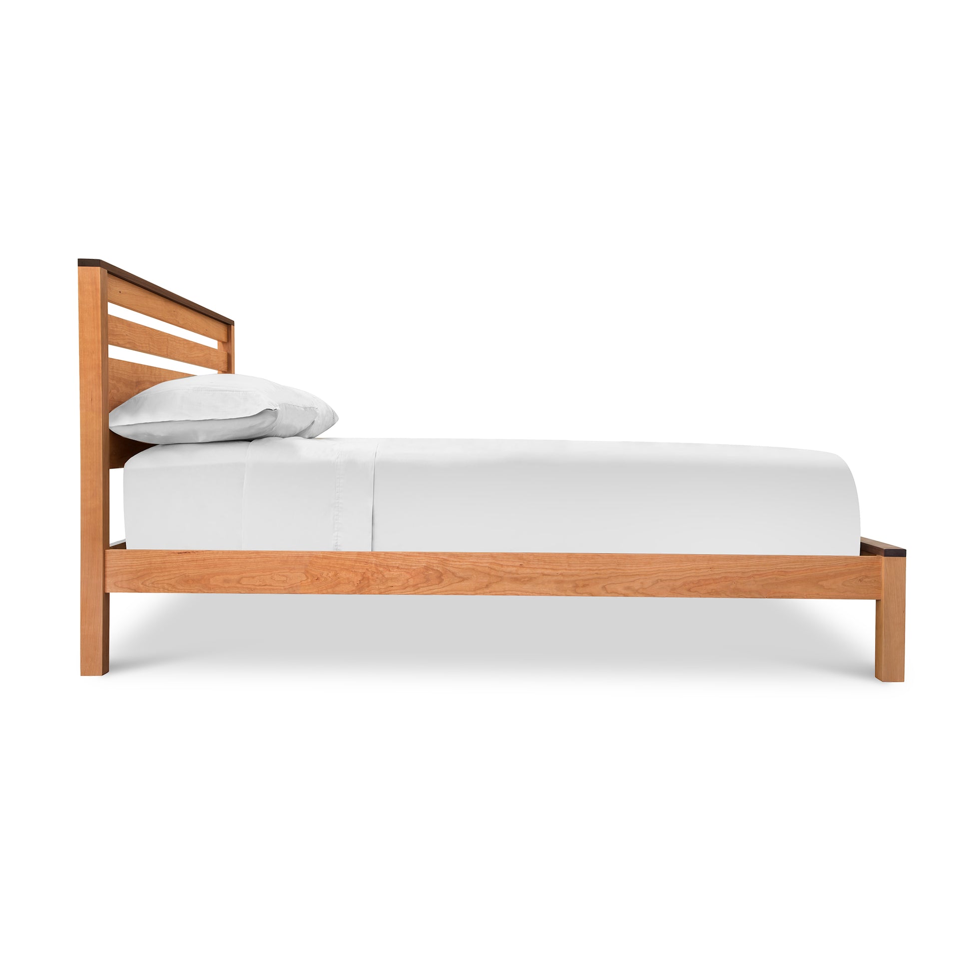 A Skyline Panel Bed - Queen - Ready to Ship with a wooden frame and white sheets, crafted from solid hardwoods and featuring an eco-friendly oil finish, made by Vermont Furniture Designs.