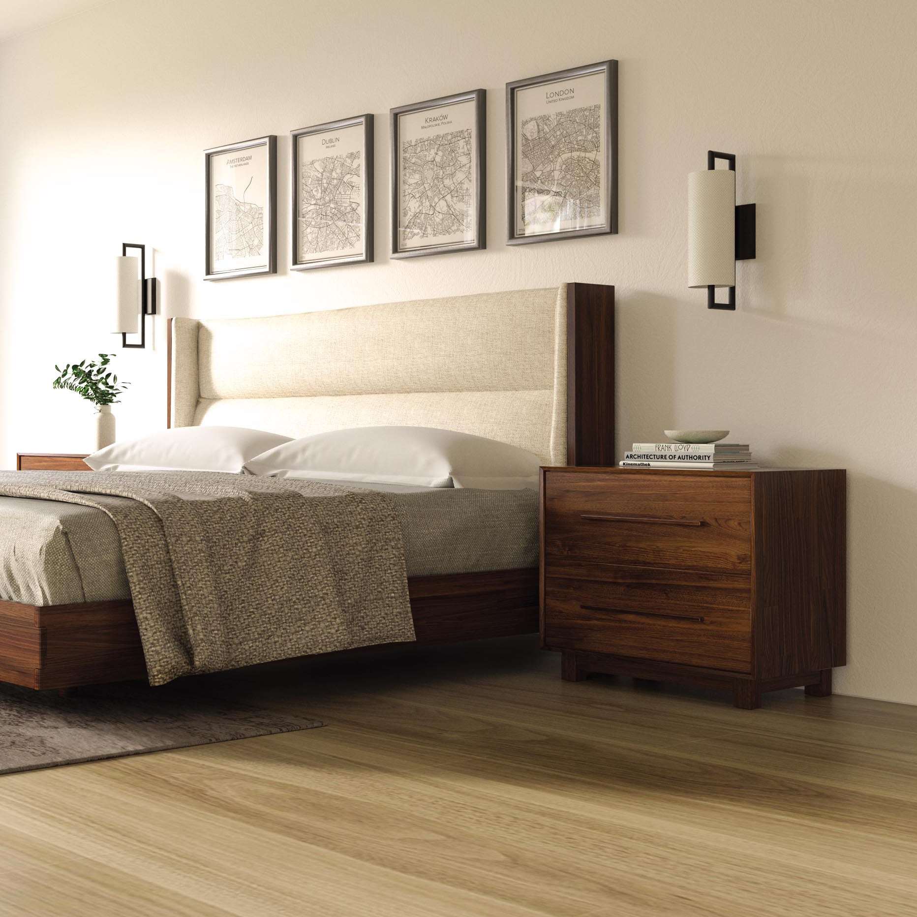 A neatly made bed with a beige headboard and wooden frame is positioned against a wall adorned with four framed artworks. Two wall-mounted lights flank the bed, and a Copeland Furniture Sloane 2-Drawer Nightstand holding books is to the right, perfectly complementing the mid-century modern aesthetic of the light-colored wood floor.