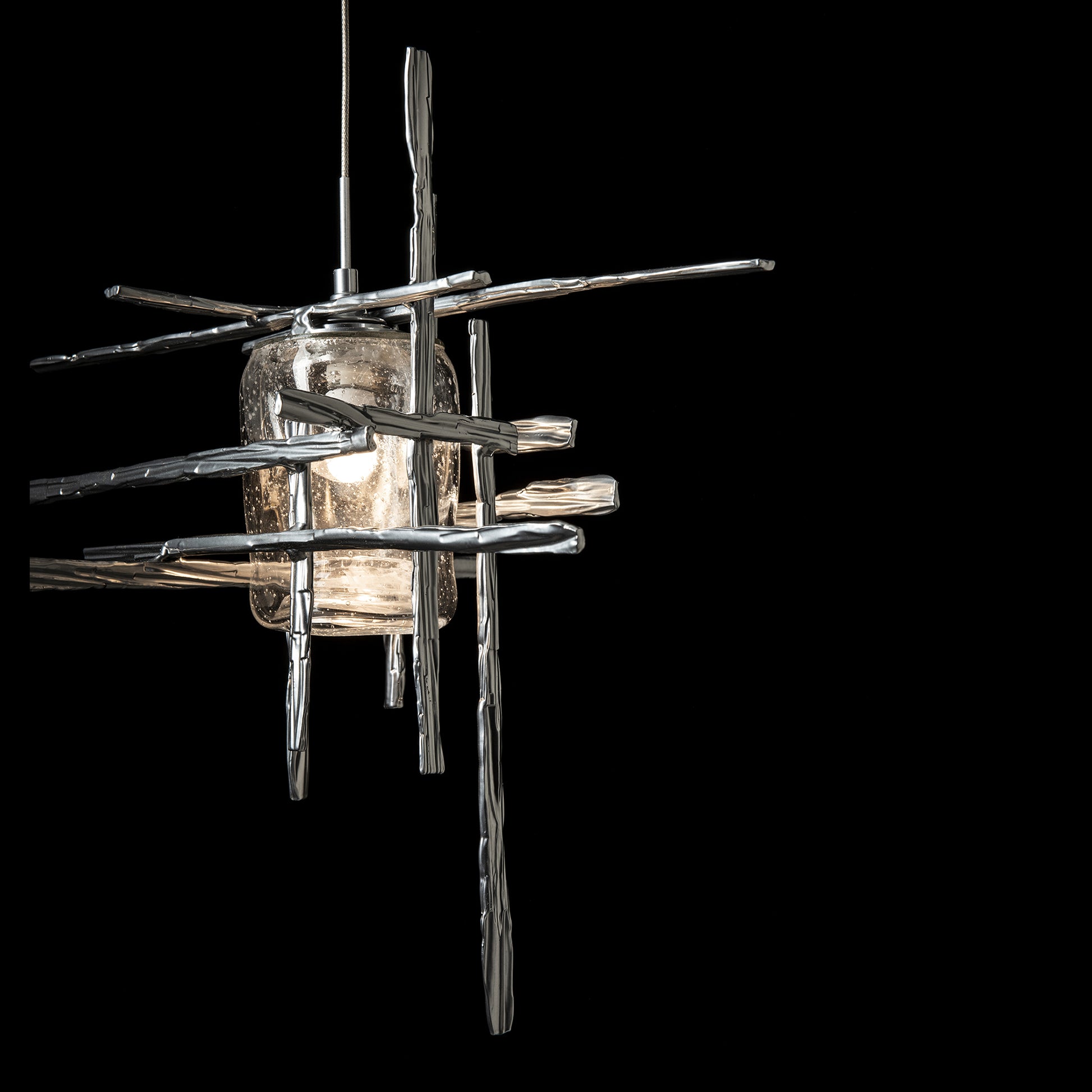 Close-up of the Tura Seeded Glass Low Voltage Mini Pendant by Hubbardton Forge, showcasing its modern glass and metal rod design.