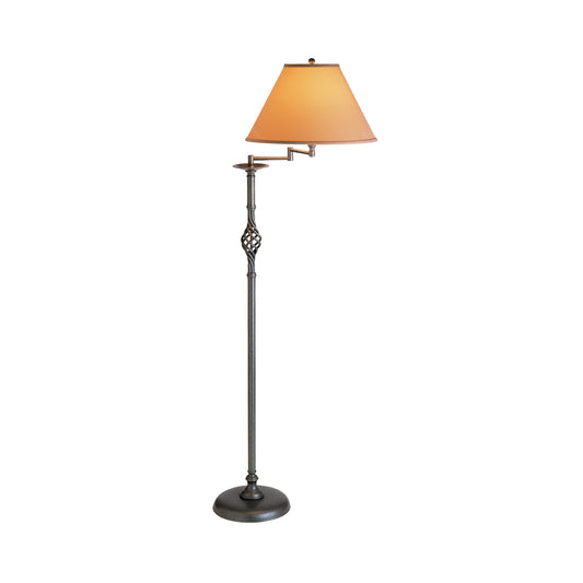 Floor lamp featuring a Hubbardton Forge Twist Basket with Swing Arm stand and an adjustable arm, topped with a cone-shaped beige shade, isolated on a white background.