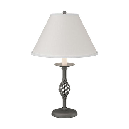 Twist Basket Table Lamp by Hubbardton Forge with a handcrafted dark, twisted metal base and white shade, showcasing elegant Vermont craftsmanship.
