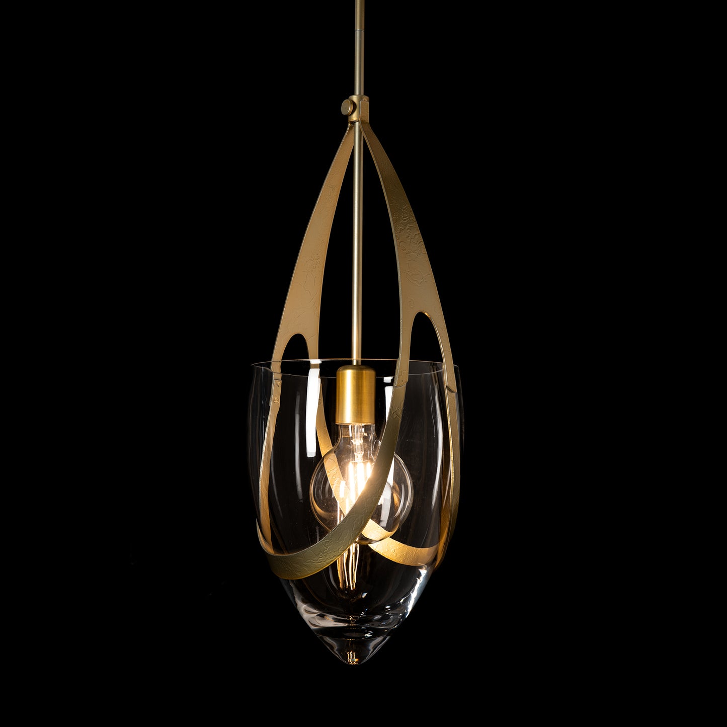 The Vaso Pendant by Hubbardton Forge showcases artisanal clear glass, elegant gold accents, and an exposed bulb, highlighting American craftsmanship.
