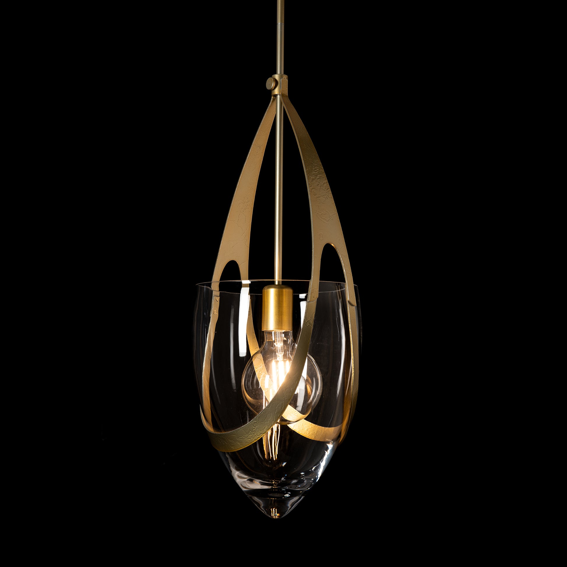 The Vaso Pendant by Hubbardton Forge showcases artisanal clear glass, elegant gold accents, and an exposed bulb, highlighting American craftsmanship.