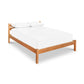 Vergennes Platform Bed by Vermont Furniture Designs, king-size, featuring a sleek design with a white mattress and two pillows.