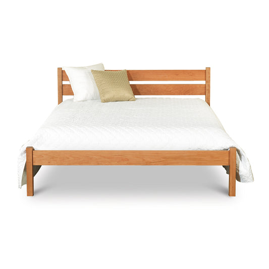 A wooden bed with a white pillow on top.