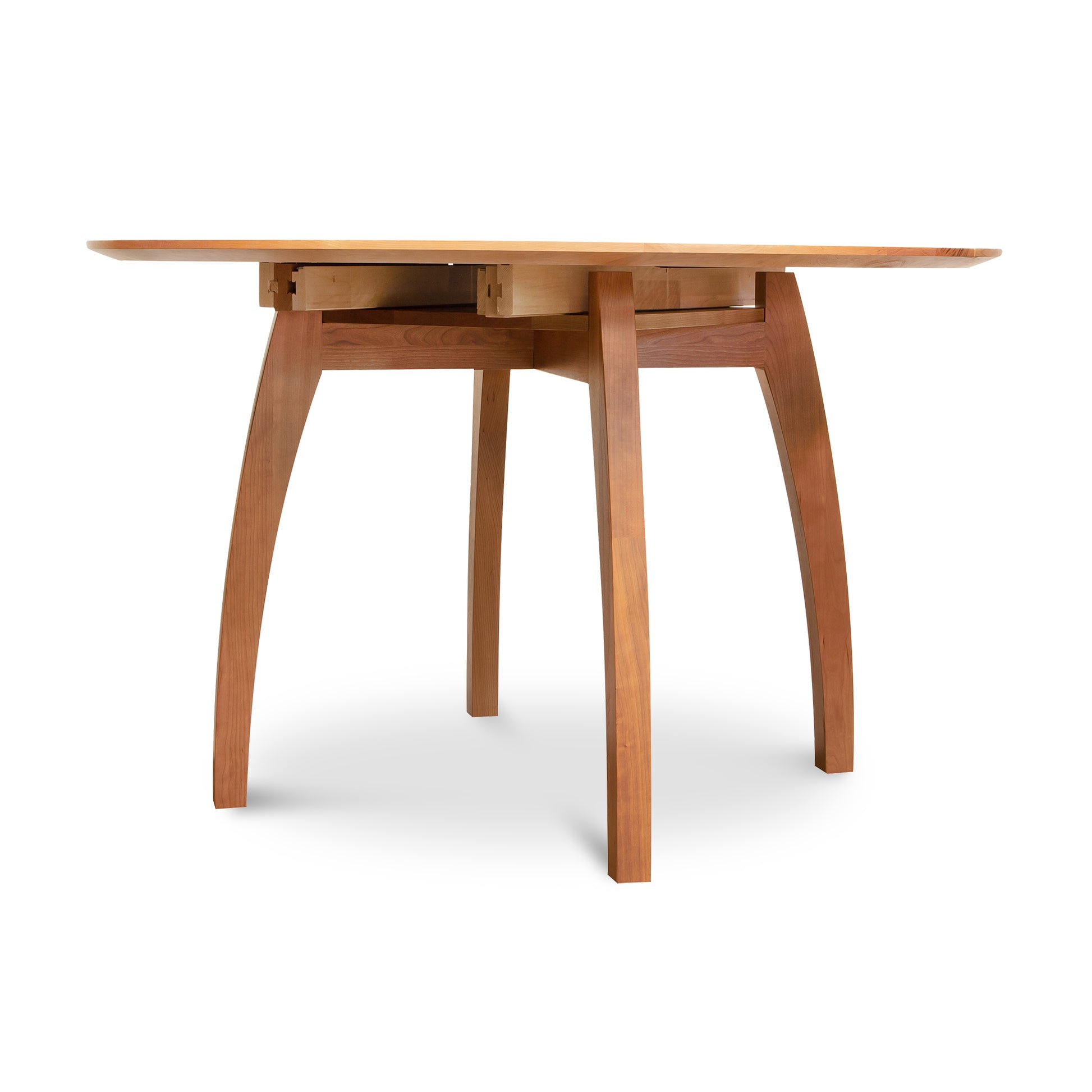 Vermont Modern Round Pedestal Extension Table by Lyndon Furniture with solid wood curved legs and a round top, showcasing craftsmanship and style.