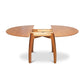 Vermont Modern Round Pedestal Extension Table in solid wood with extended leaves and visible extension mechanism by Lyndon Furniture.