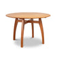 A Lyndon Furniture Vermont Modern Round Solid Top Pedestal Table crafted with organic wood, skillfully handmade to perfection, featuring a round shape and supported by two sturdy legs.