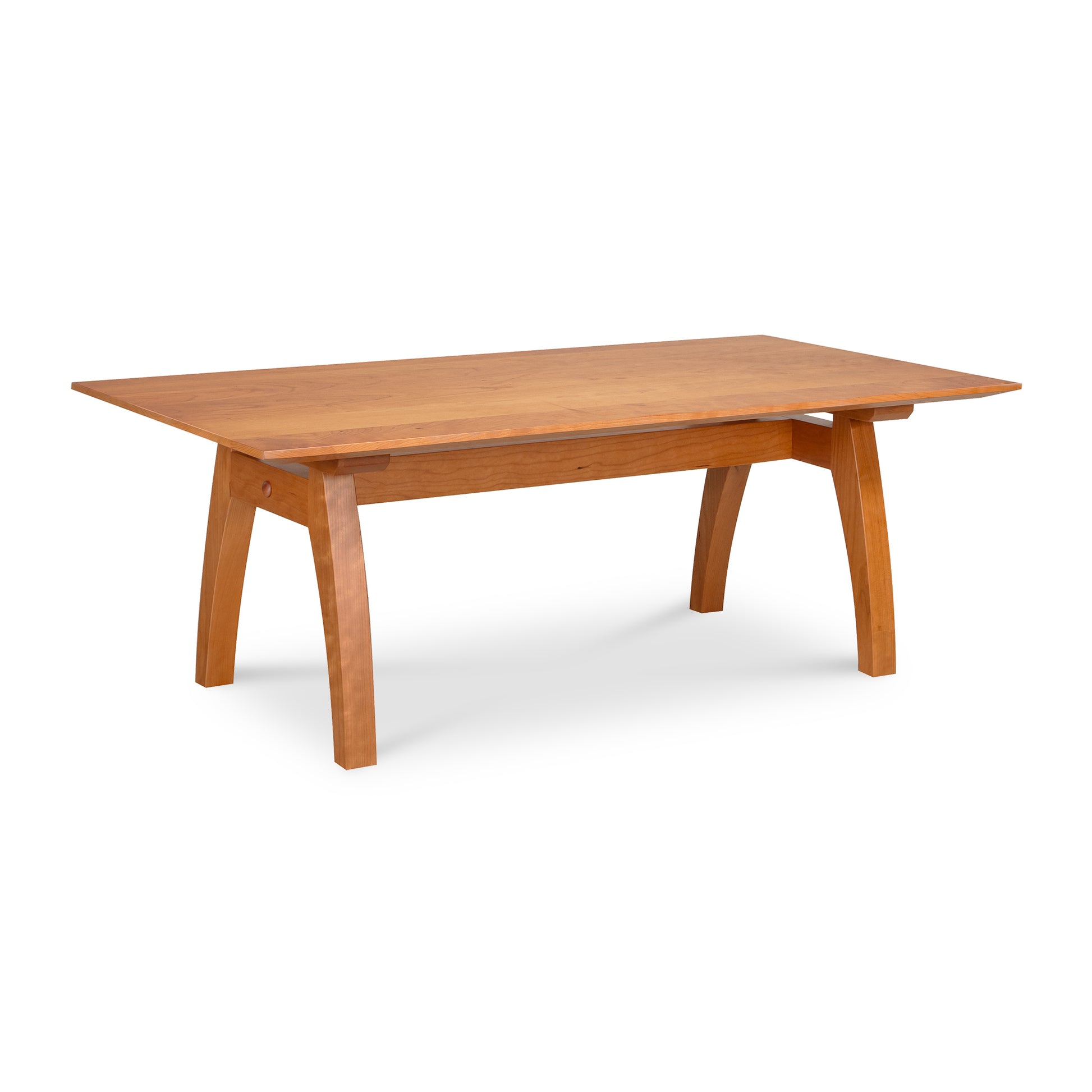 Light brown wooden dining table with thick slanted legs and flat tabletop, resembling Vermont Modern Trestle Coffee Table by Lyndon Furniture.