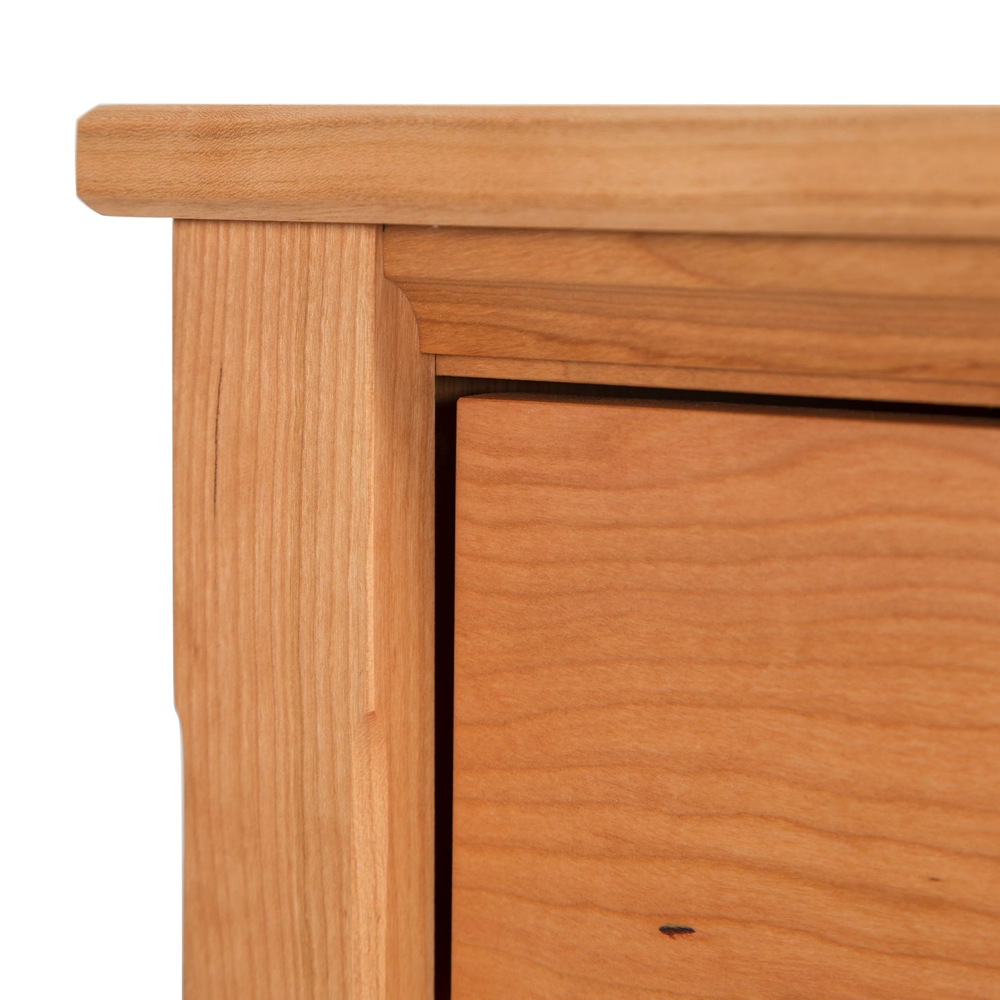 Close-up of the Vermont Shaker 1-Drawer Enclosed Shelf Nightstand - Display Model by Maple Corner Woodworks. The image highlights the rich grain and texture of American-made, sustainably harvested hardwood furniture. Showcasing expert craftsmanship with precise joinery, this cherry wood nightstand is a perfect example of high-quality solid wood furniture made in Vermont.