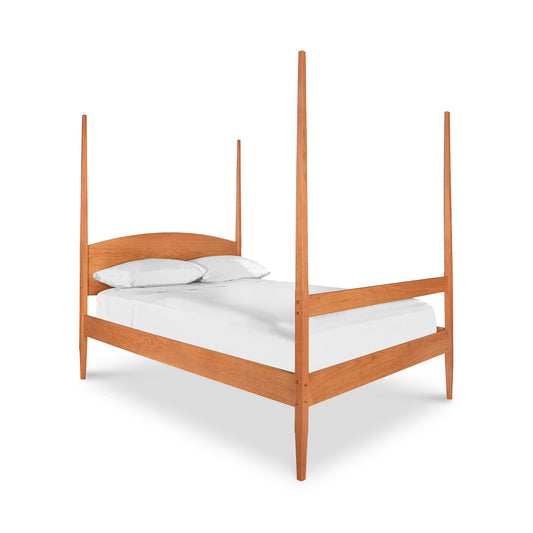 Vermont Shaker Four Poster Bed by Maple Corner Woodworks, showcasing its solid wood craftsmanship and subtly curved headboard, accompanied by a white sheet and two pillows.