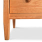 Close-up of a handcrafted wooden Vermont Shaker 7-Drawer Dresser featuring a single drawer with a round knob and angled legs, isolated on a white background by Maple Corner Woodworks.