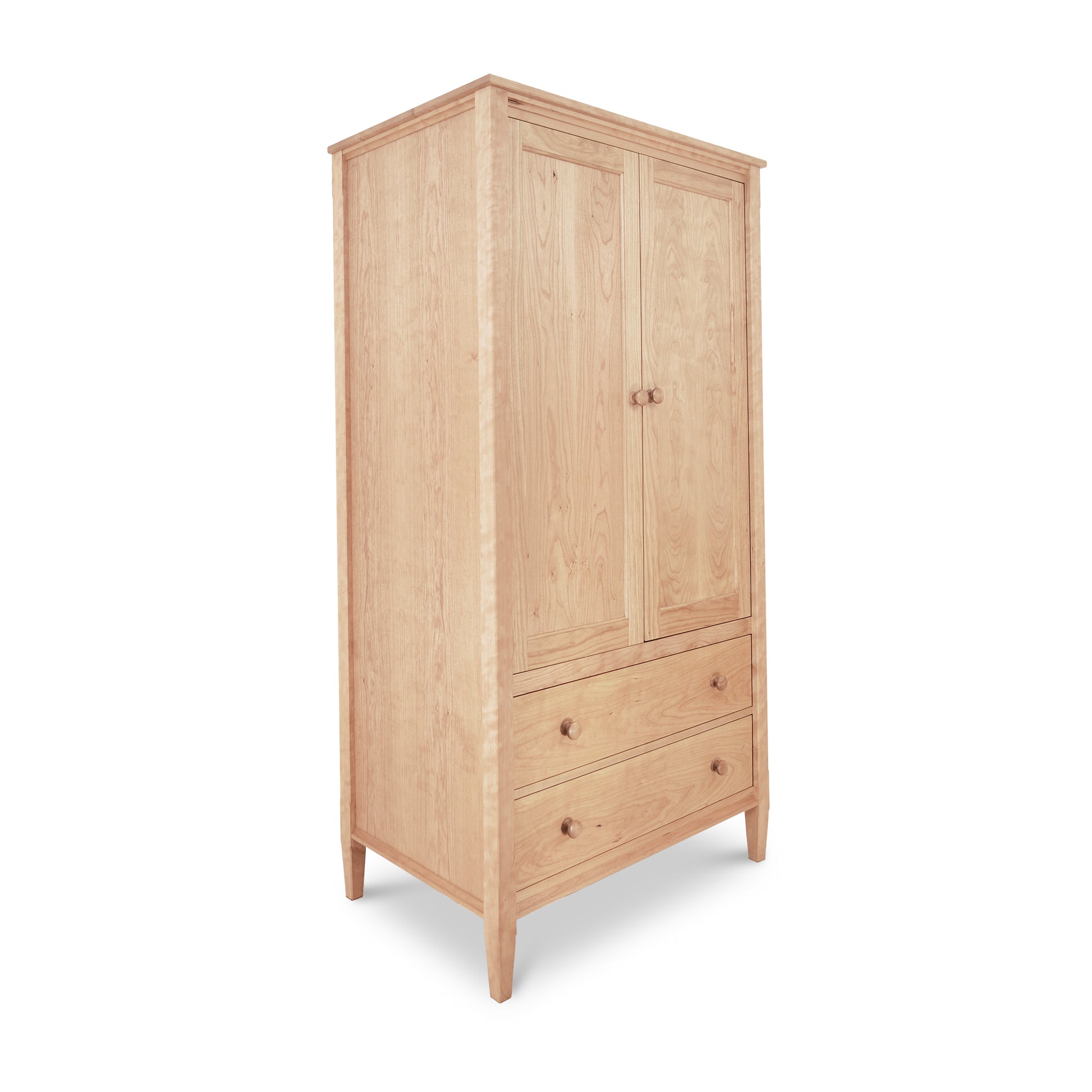 A Vermont Shaker Armoire from Maple Corner Woodworks with a tall, rectangular shape featuring a single large door and a lower drawer, all in a light natural wood finish, isolated on a white background.