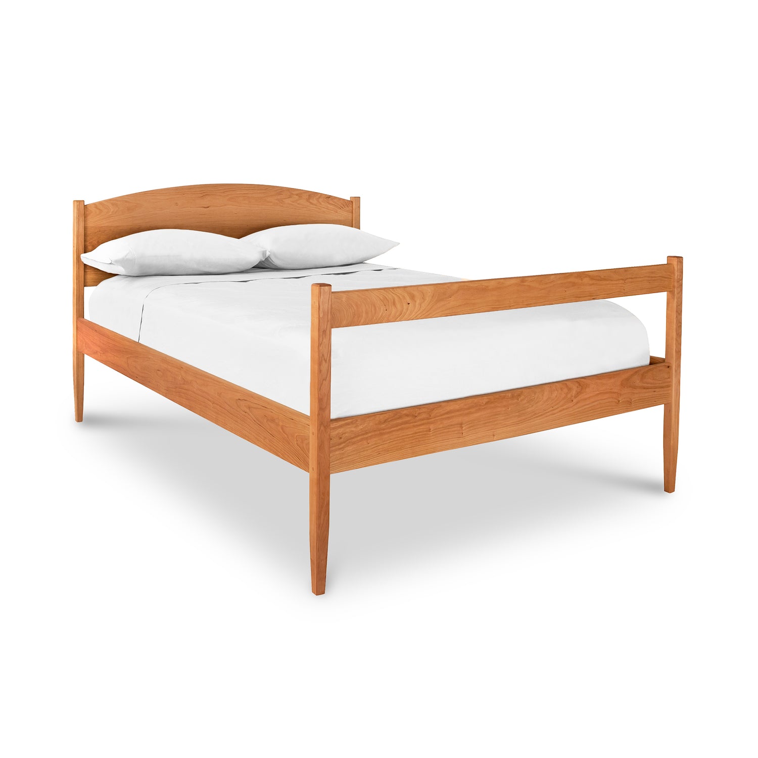 The Vermont Shaker Bed by Maple Corner Woodworks is a wooden platform bed with a minimalist design, featuring a headboard and footboard crafted from solid hardwood. It showcases a natural wood finish and includes a plain white mattress and two pillows, all set against a plain white background.