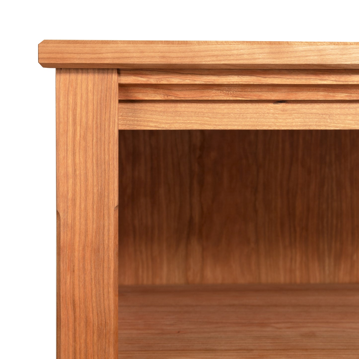 Detailed view of the Vermont Shaker Bookcase corner by Maple Corner Woodworks, highlighting the wood grain and interior shelf, crafted from sustainably harvested hardwoods to showcase the natural color and texture.