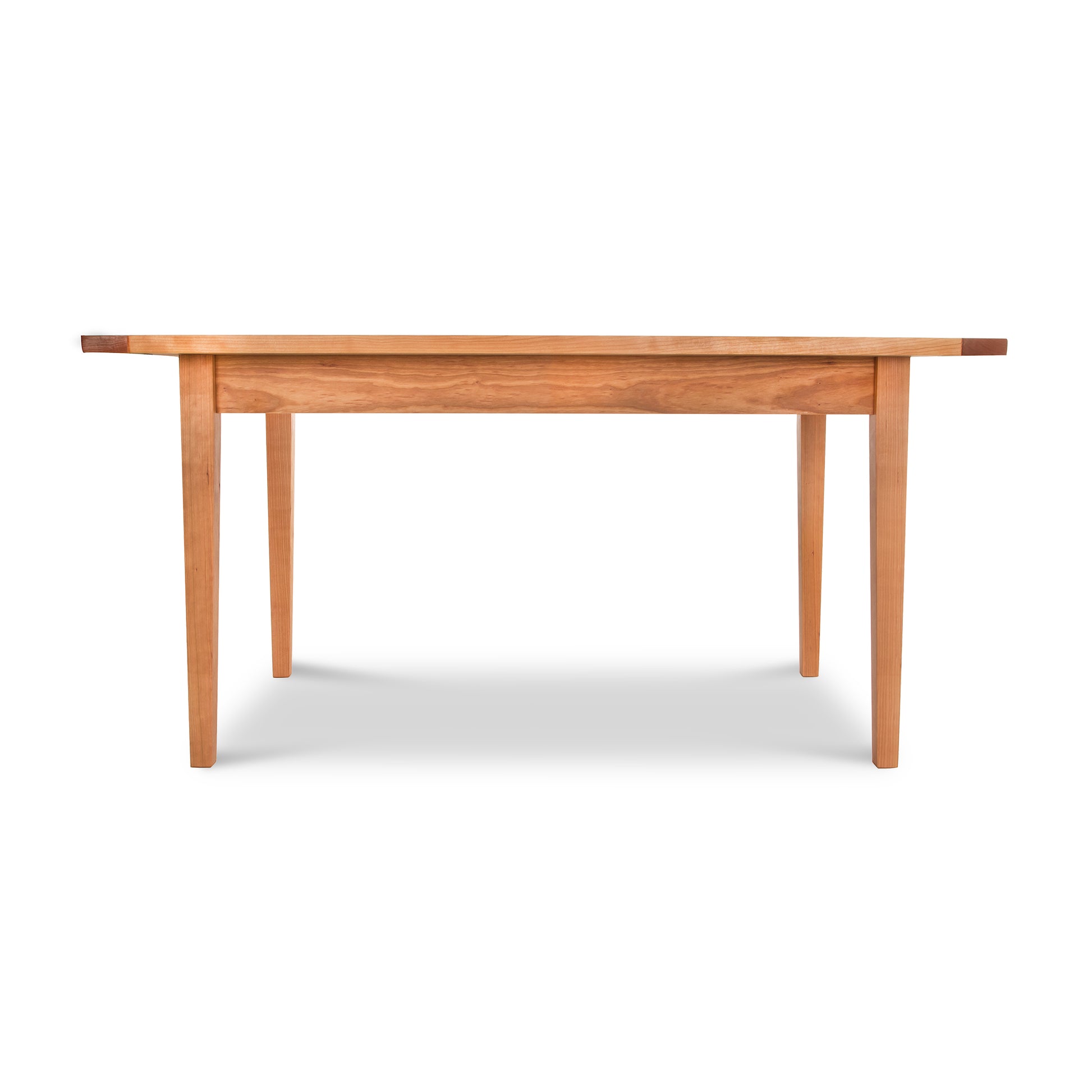 A warm Maple Corner Woodworks Vermont Shaker Harvest Extension Dining table with a wooden top.
