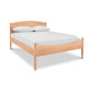 An eco-friendly Maple Corner Woodworks Vermont Shaker Moon Bed with a wooden frame and white sheets.