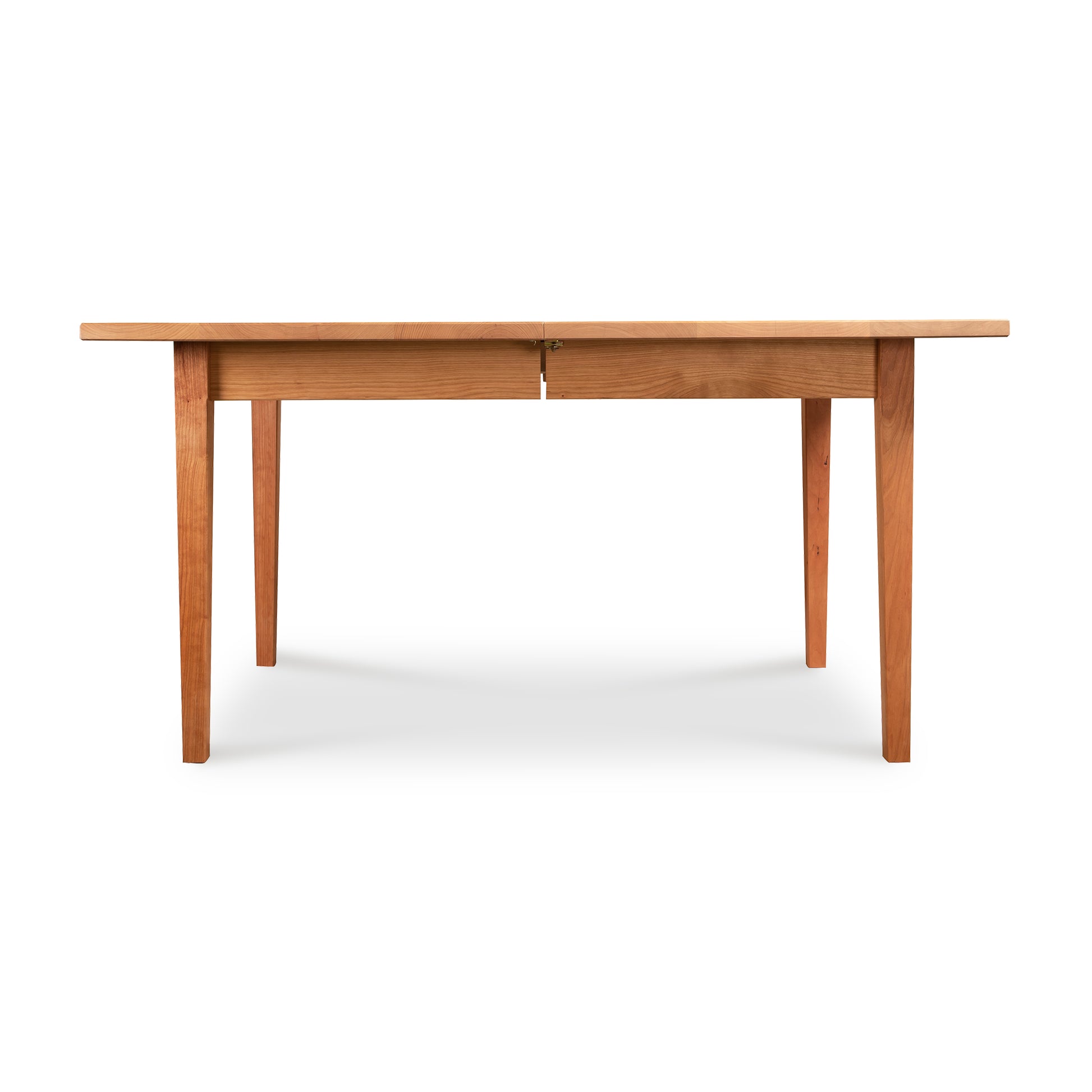The Vermont Shaker Rectangular Extension Dining Table by Maple Corner Woodworks is a handcrafted solid wood table with two legs and two drawers.