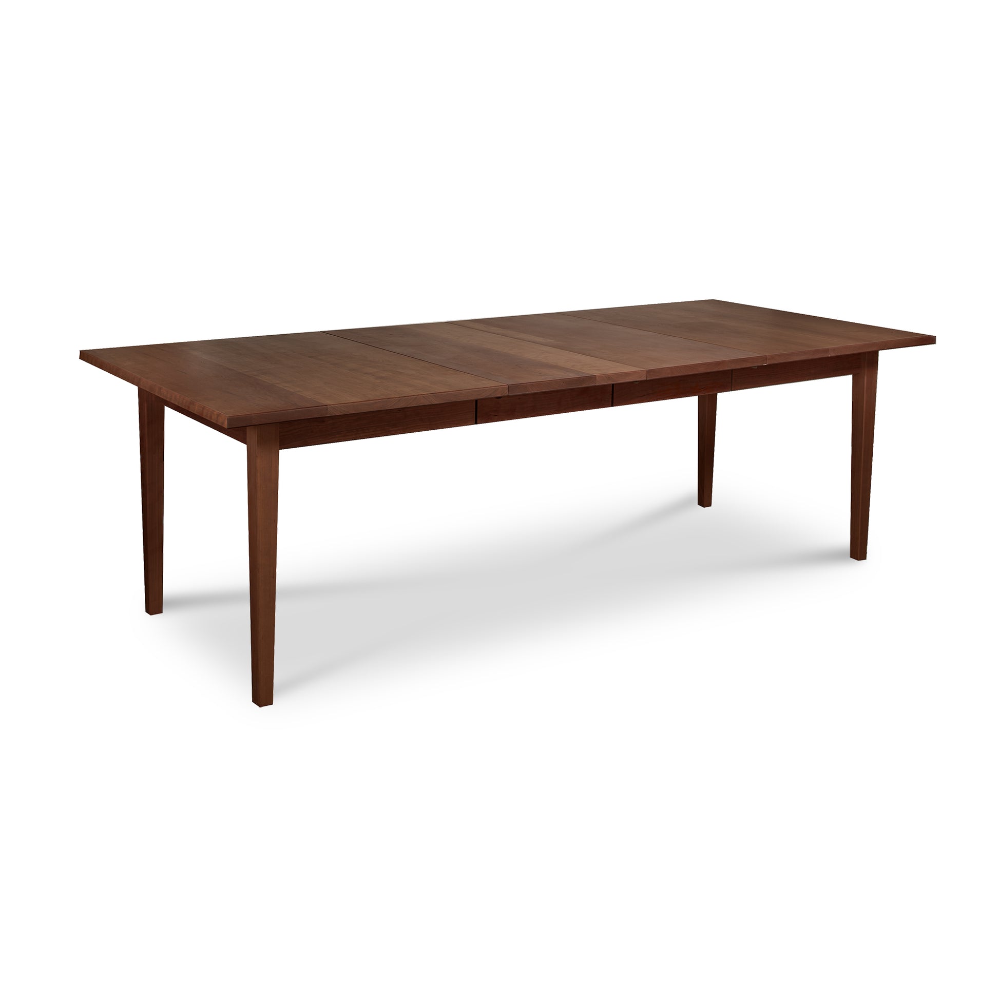 A Vermont Shaker Rectangular Extension Dining Table made of sustainably harvested wood, featuring tapered legs, displayed against a white background by Maple Corner Woodworks.