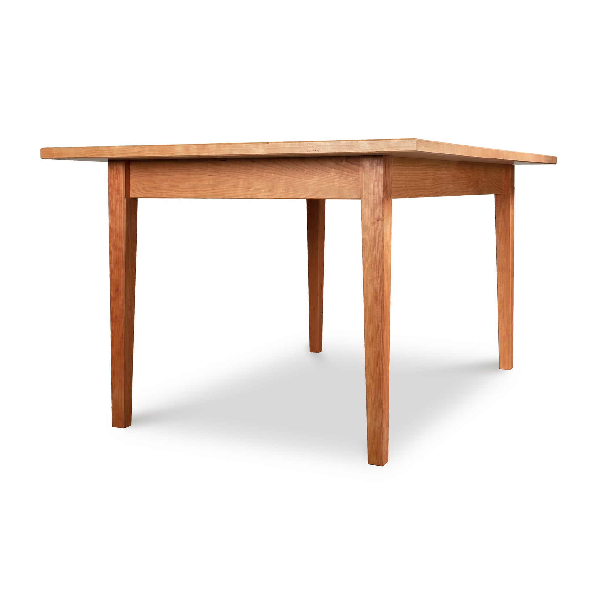 Alt Text: Vermont Shaker Rectangular Solid Top Dining Table by Maple Corner Woodworks in light brown finish - American-made, sustainably harvested solid wood furniture with four straight legs and a simple, modern design. Plain white background.