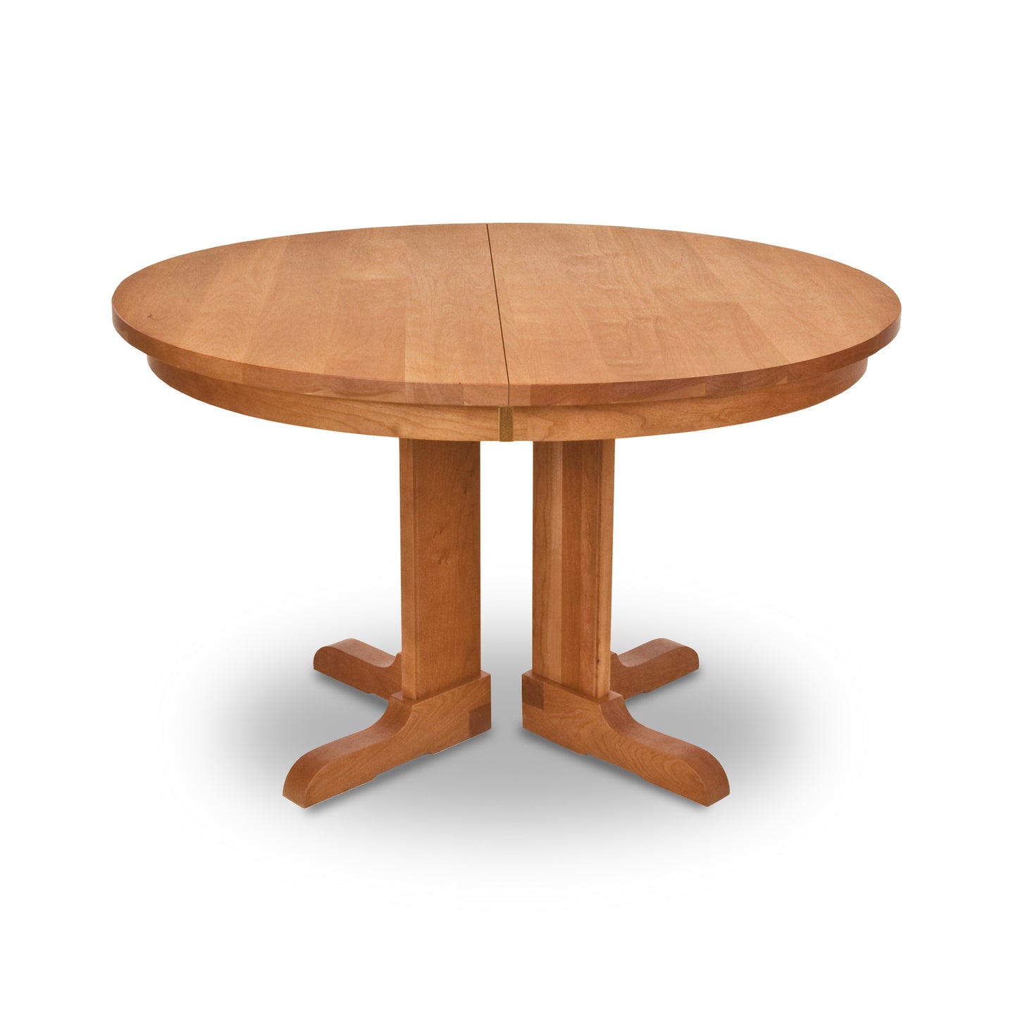 A Vermont Traditions Split Pedestal Round Extension Table by Lyndon Furniture, a hand-crafted wooden dining table with two sturdy legs.