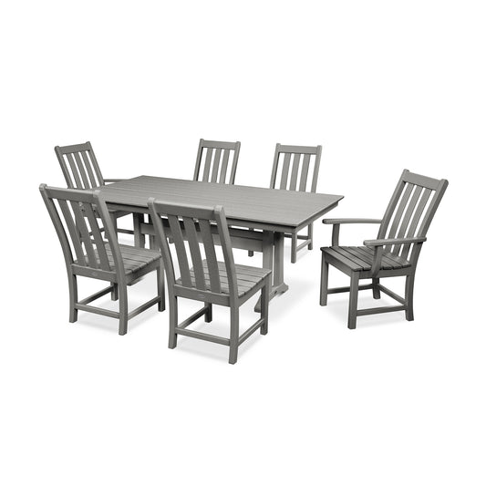 A gray outdoor dining set comprising one rectangular POLYWOOD Vineyard farmhouse trestle table and six matching chairs, all made of slatted, synthetic materials, displayed on a plain white background.