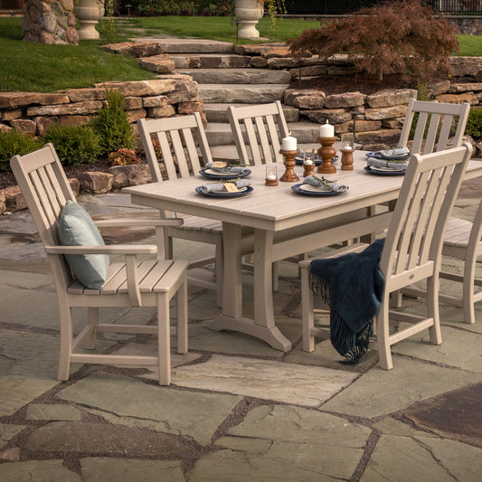 Beige POLYWOOD Vineyard Dining Chairs arranged with place settings and a blue throw, showcasing American-made outdoor furniture quality.
