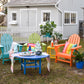 In a backyard setting, vibrant POLYWOOD Vineyard Adirondack Chairs in shades of blue, green, yellow, and orange are arranged around a blue table covered with a striped cloth. The chairs are made from durable POLYWOOD lumber and beautifully offset the gray shed and white picket fence. A plant and jar adorn the tabletop.