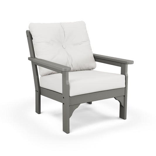 A modern outdoor chair featuring a gray frame and thick, all-weather fabric cushions, complemented by a plump white pillow against a plain white background. 
Product Name: POLYWOOD Vineyard Deep Seating Chair
Brand Name: POLYWOOD